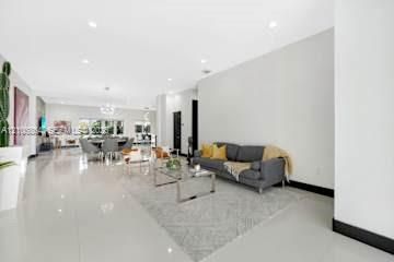 Open-concept living space featuring high ceilings, recessed lighting, and polished stone flooring throughout
