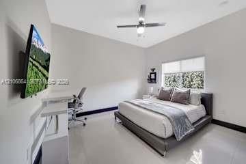 Neutral interior featuring high-gloss tile flooring, smooth wall finish, recessed ceiling lighting, and a window with a retractable roller shade