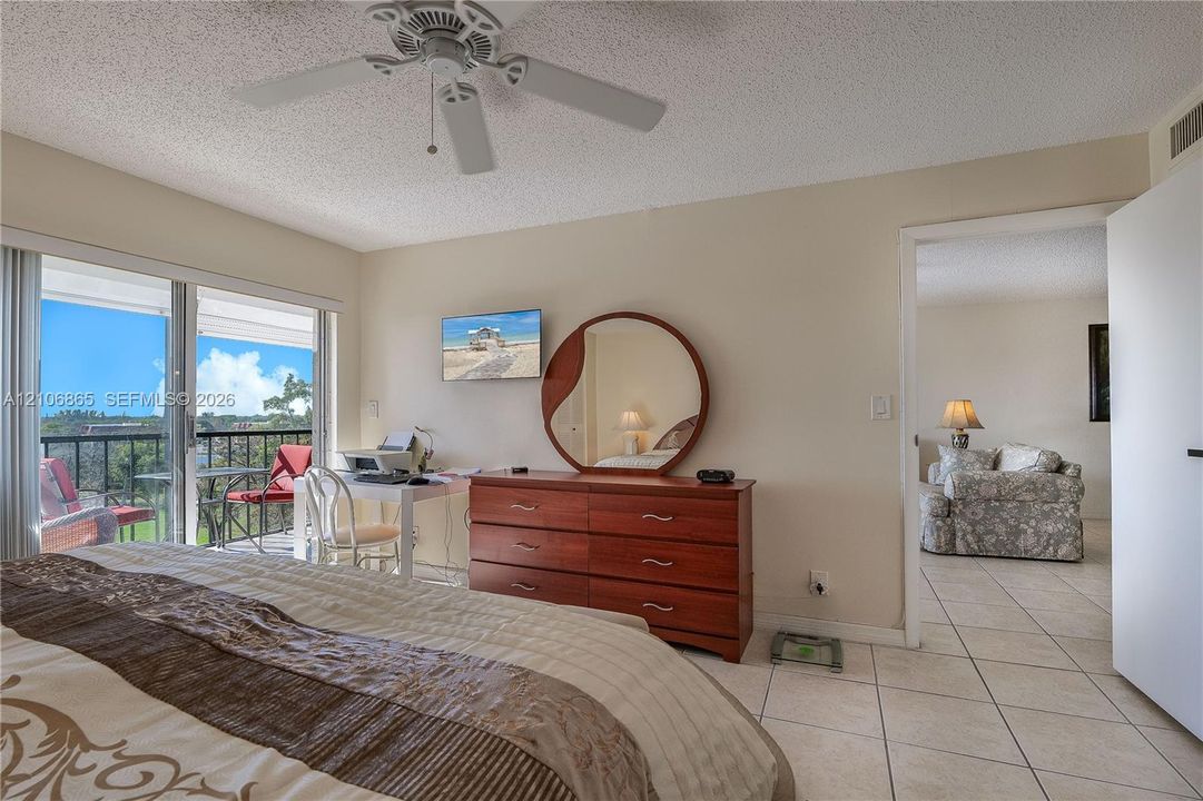 Ceramic tile flooring, white ceiling fan, and sliding glass door access to an exterior balcony