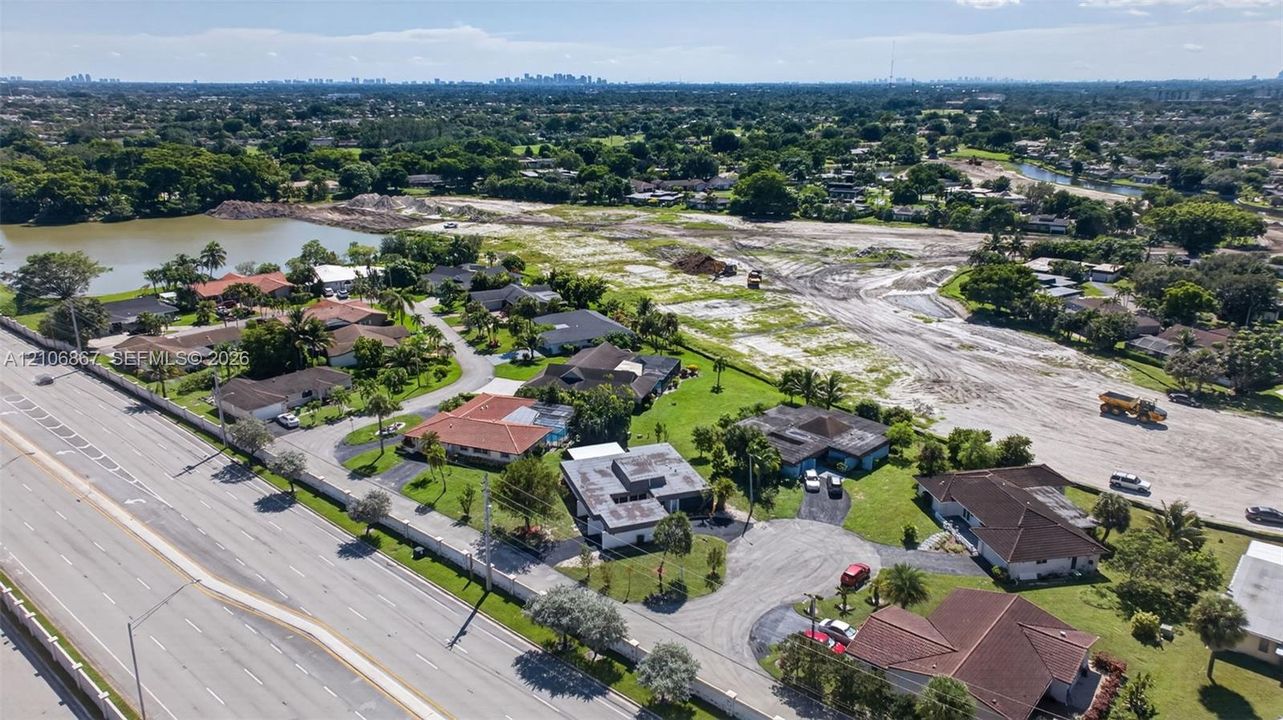 Aerial perspective of a suburban neighborhood featuring a large freshwater reservoir and surrounding green space