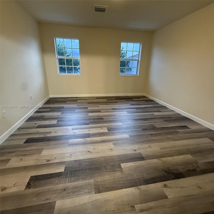 Interior space featuring wood-finish flooring and two grid-pattern windows