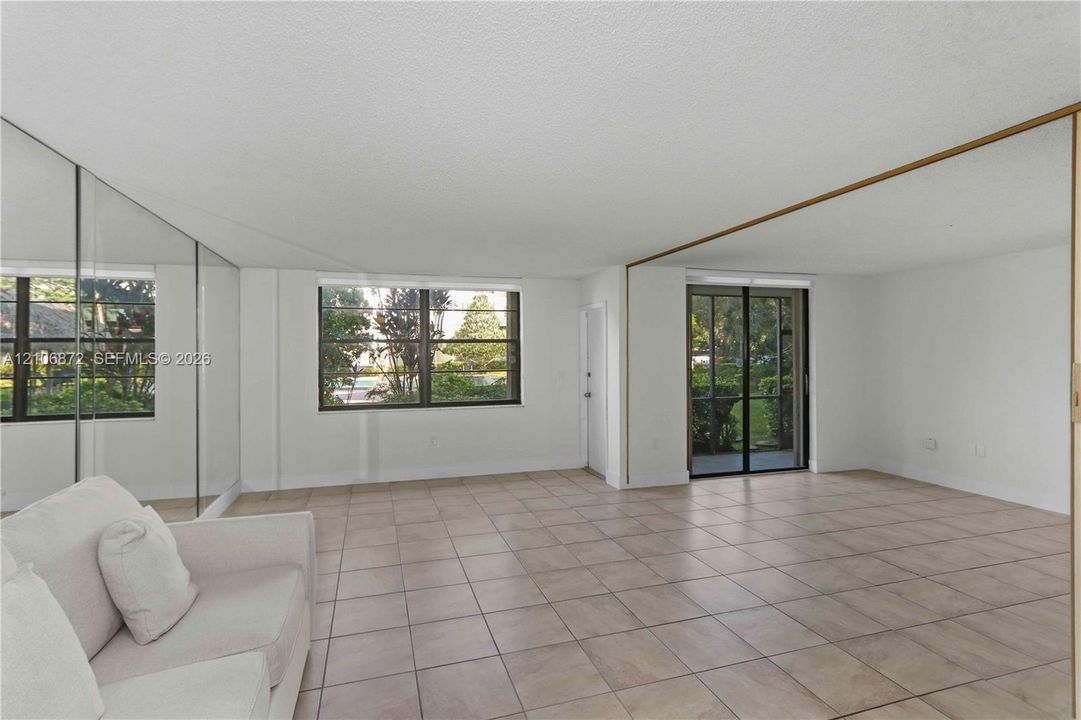 Interior space featuring tile flooring, mirrored wall panels, and multiple windowed exposures
