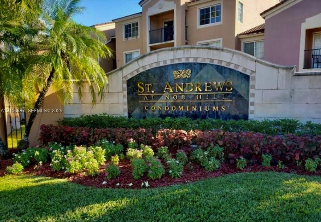 Monument sign featuring stone-finish masonry, ornamental metal lettering, integrated landscaping, and palm accents