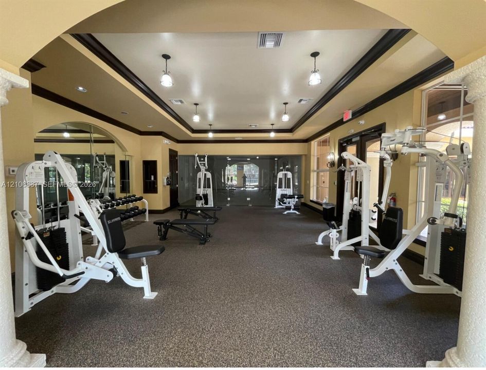 Fitness center featuring decorative columns, crown molding, recessed lighting, and wall-to-wall carpeting