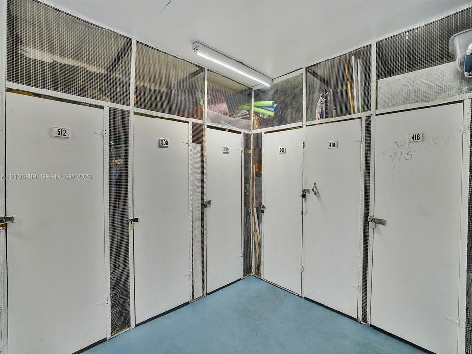 Dedicated storage lockers featuring solid-panel doors with integrated metal mesh ventilation and surface-mounted overhead lighting
