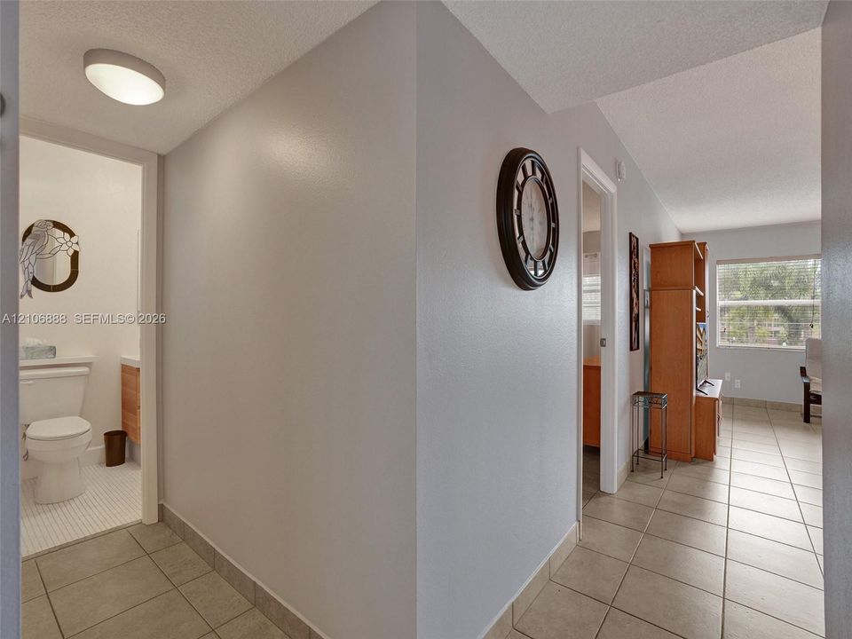 Neutral interior featuring ceramic tile flooring, a flush-mount ceiling light fixture, and a white porcelain toilet