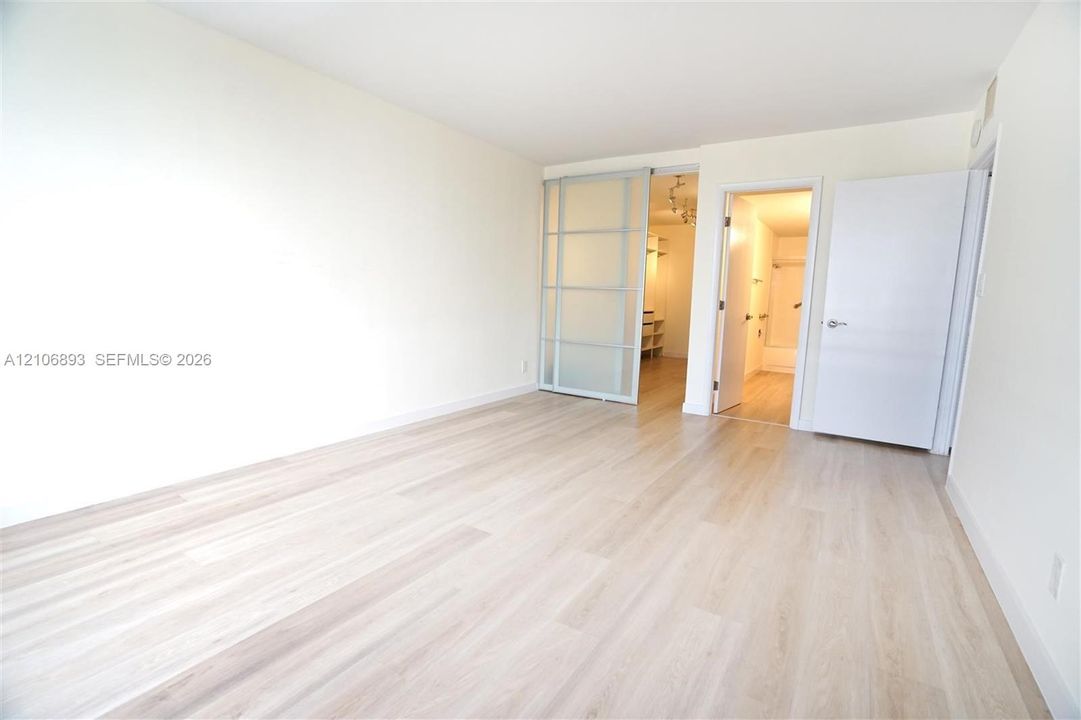 Light-toned wood-finish flooring, sliding translucent room divider, and solid-core interior doors