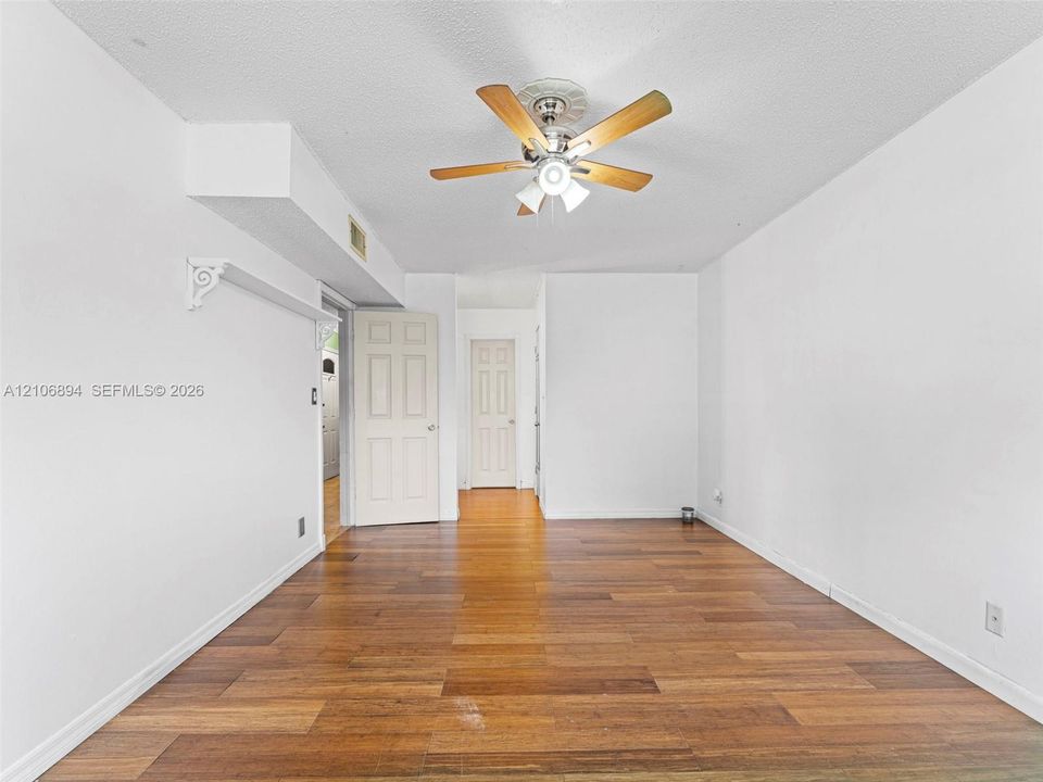 Wood-finish flooring, ceiling fan with integrated lighting, and six-panel interior doors