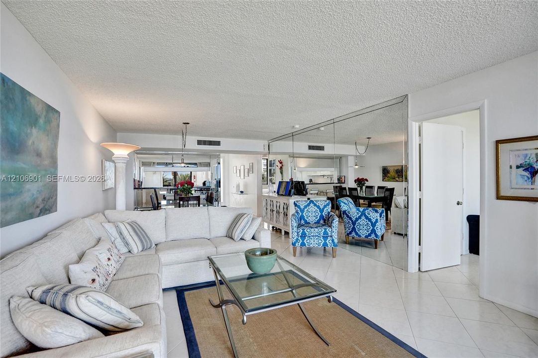 Open-concept interior featuring large-format diagonal tile flooring and floor-to-ceiling wall mirrors
