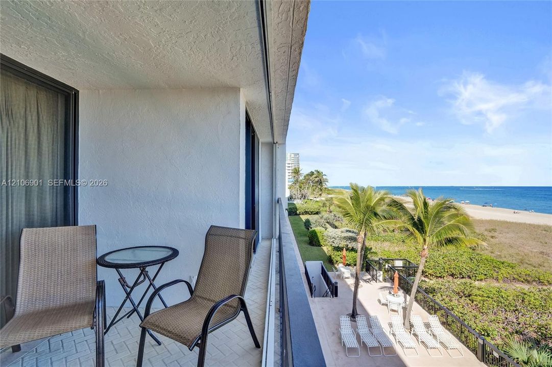 Covered balcony featuring herringbone-patterned flooring and direct oceanfront exposure