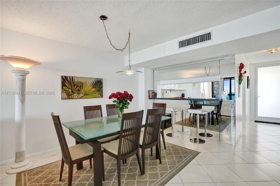 Ceramic tile flooring, mirrored wall accents, built-in breakfast bar, and pendant lighting