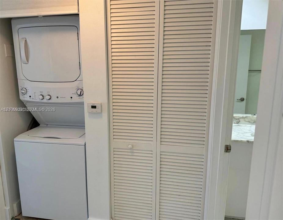 Stacked washer and dryer unit with louvered bi-fold closet doors