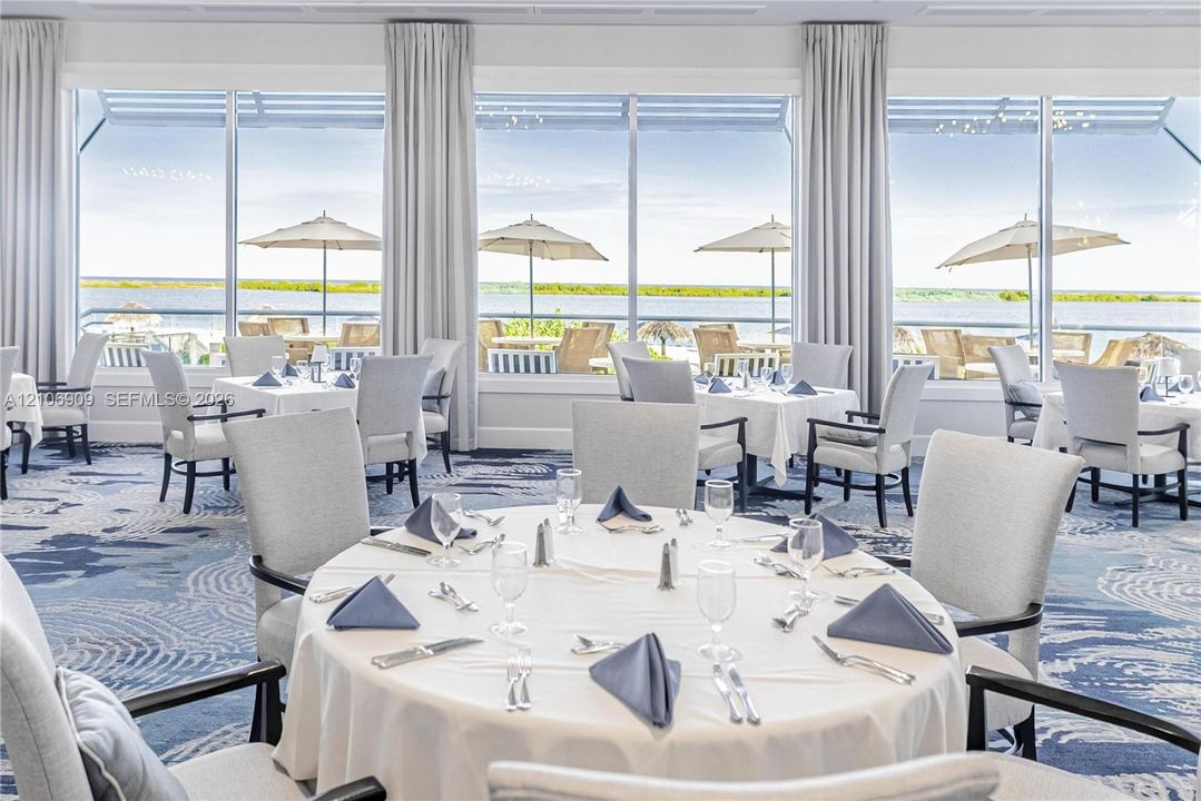 Floor-to-ceiling windows featuring panoramic water scenery and a metal-framed exterior balcony