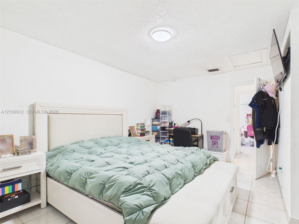 Neutral-toned tile flooring and ceiling-mounted flush lighting