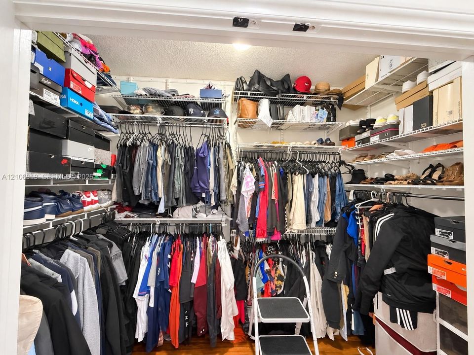 Walk-in closet featuring tiered wire shelving and multiple hanging rods