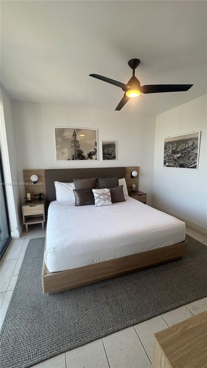 Built-in headboard featuring integrated wooden side tables, minimalist wall-mounted spherical light fixtures, and a matte black ceiling fan