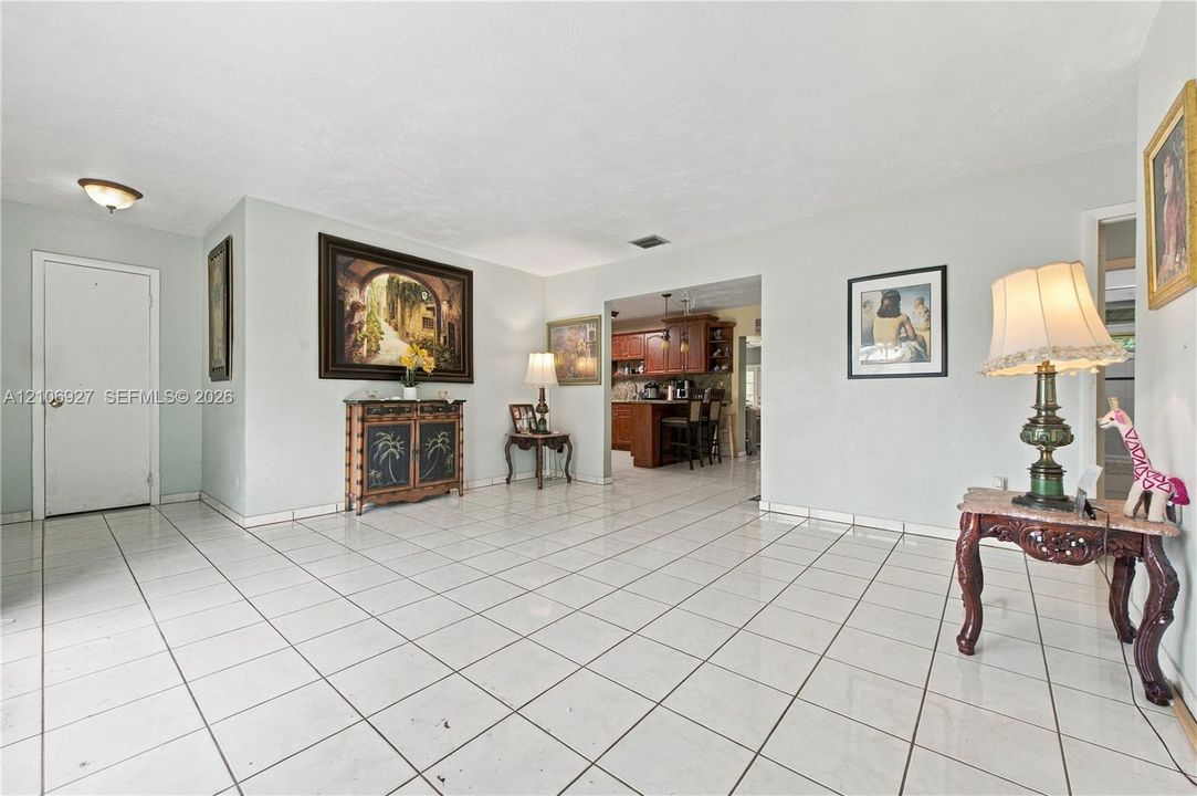Living area featuring large-format ceramic tile flooring, neutral wall tones, and recessed lighting