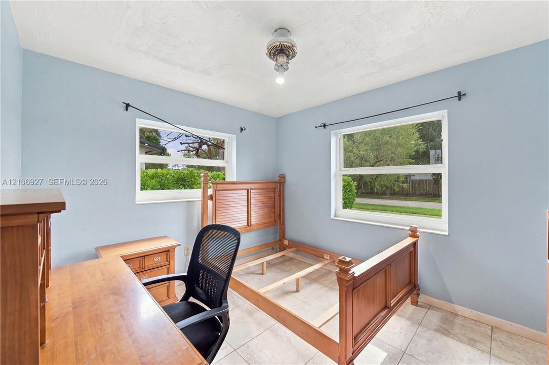 Room featuring tile flooring, neutral wall paint, and dual windows with built-in curtain rods