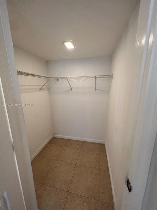 Walk-in storage space featuring ceramic tile flooring, neutral walls, and integrated wire shelving