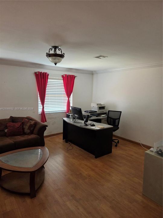 Wood-finish flooring, crown molding, and a semi-flush mount light fixture