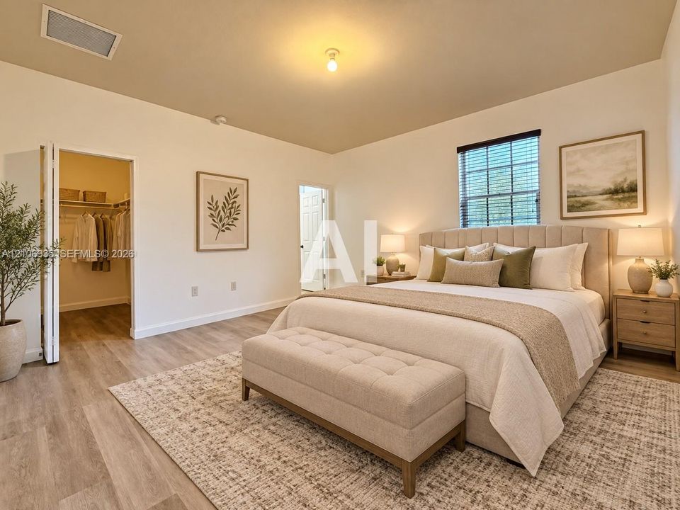 Spacious bedroom featuring wood-finish flooring, a large walk-in closet with built-in shelving, and a dual-pane window with interior blinds