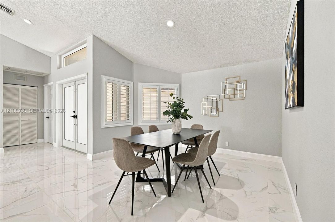 High-gloss tile flooring, vaulted ceilings, double entry doors with glass inserts, transom windows, and window shutters