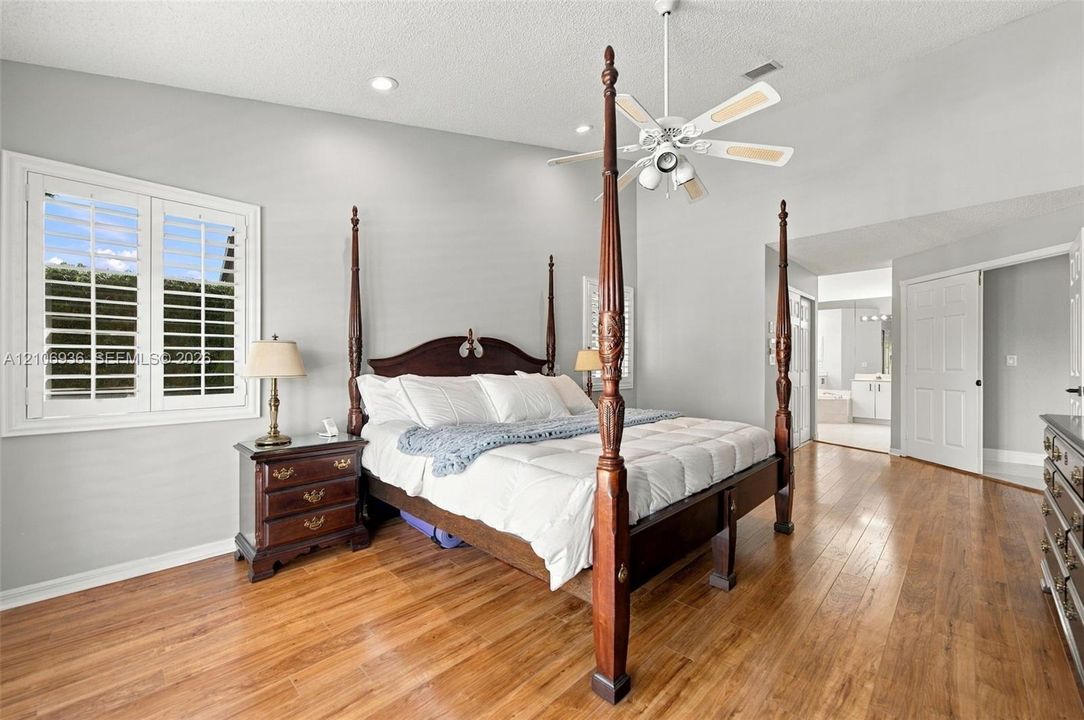 Vaulted ceilings featuring recessed lighting, wood-finish flooring, plantation shutters, and a ceiling fan with integrated lighting
