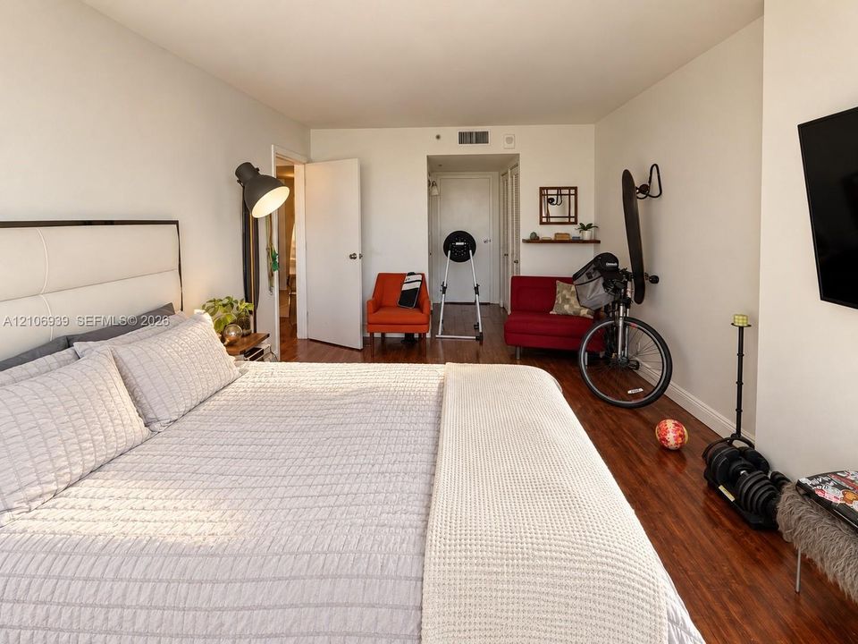 Room featuring dark wood-finish flooring, a wall-mounted floating wood shelf, and neutral wall tones