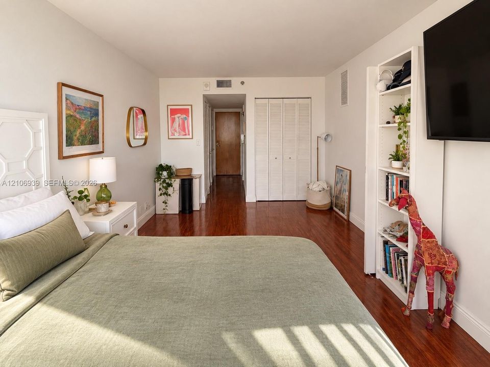 Bedroom interior featuring wood-finish flooring and a closet with bifold doors