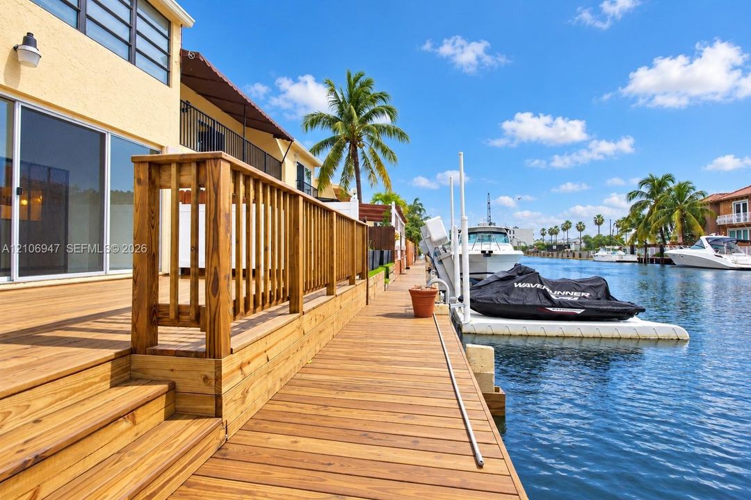 Waterfront wood decking featuring a railed staircase and built-in boat lift