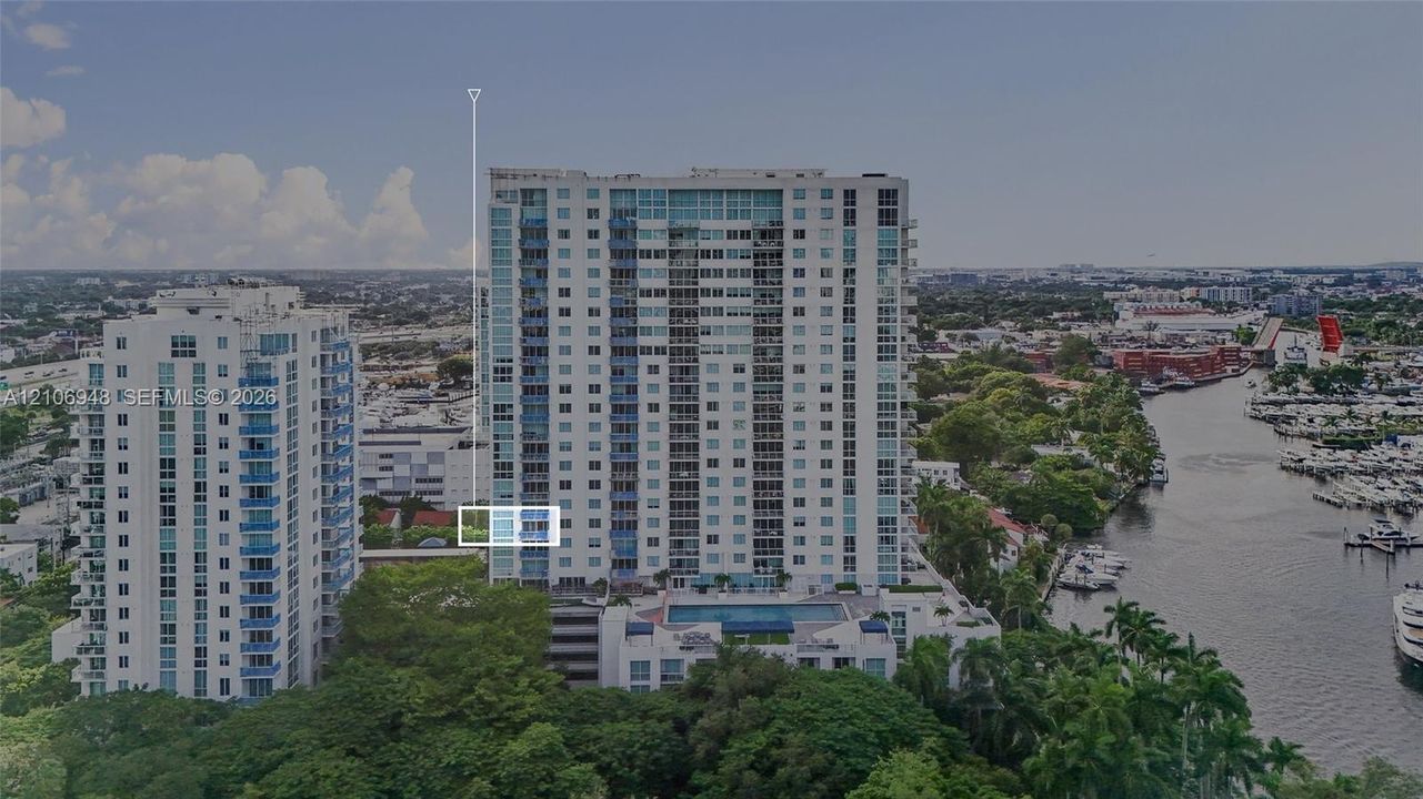 High-rise residential building featuring floor-to-ceiling glass windows, exterior balconies, and an elevated outdoor swimming pool
