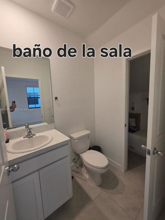 Bathroom featuring white cabinetry, solid-surface vanity countertop with an integrated sink, polished metal faucet, and tile flooring
