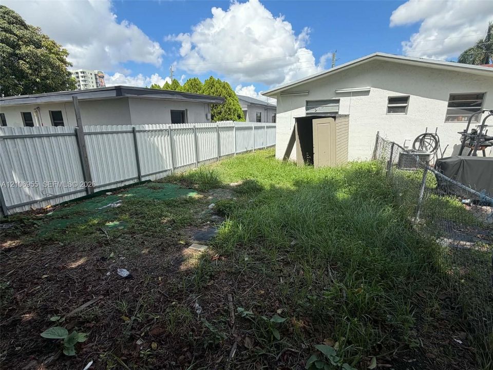 Exterior space enclosed by vertical vinyl fencing and chain-link perimeter