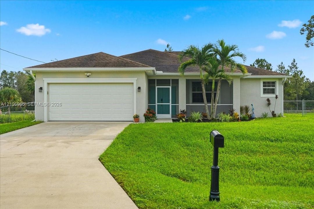 Single-story exterior featuring a stucco facade, hipped roof, attached two-car garage, and a covered entryway with a screened enclosure