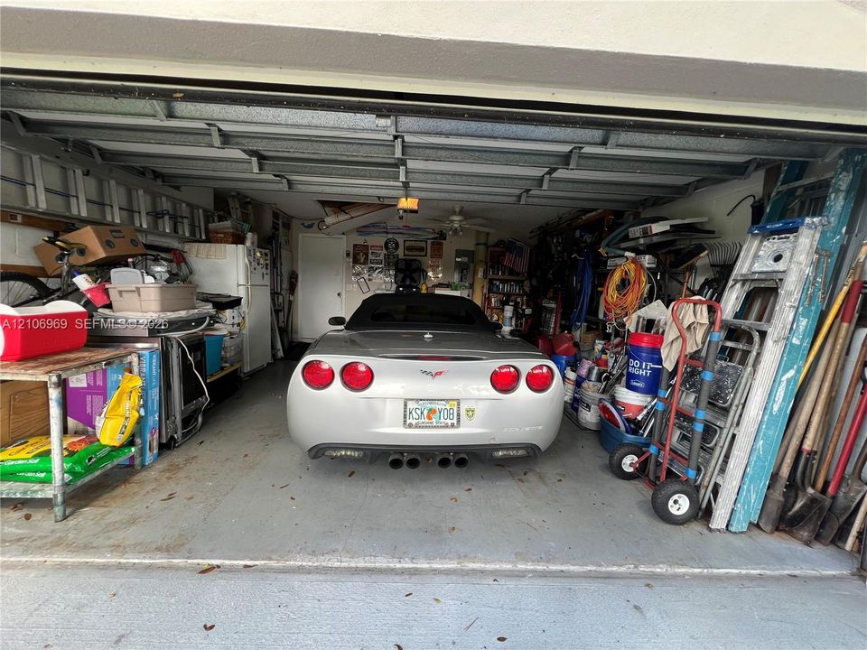 Enclosed garage featuring a concrete floor, overhead door track system, and ceiling-mounted lighting