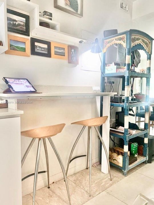 Built-in white wall-mounted desk with quartz countertop and coordinating floating shelving