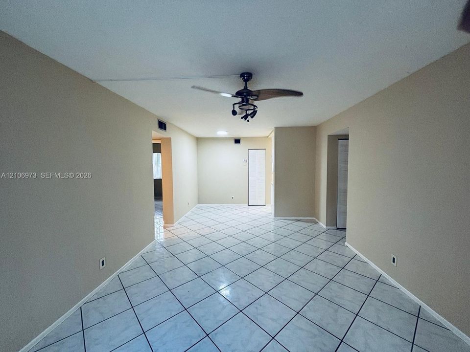 Interior space featuring diagonal tile flooring, neutral wall tones, and a ceiling fan with integrated lighting