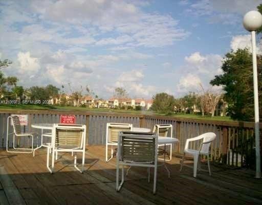 Wood-plank deck featuring a vertical-slat perimeter railing, integrated pole lighting, and a water-front location