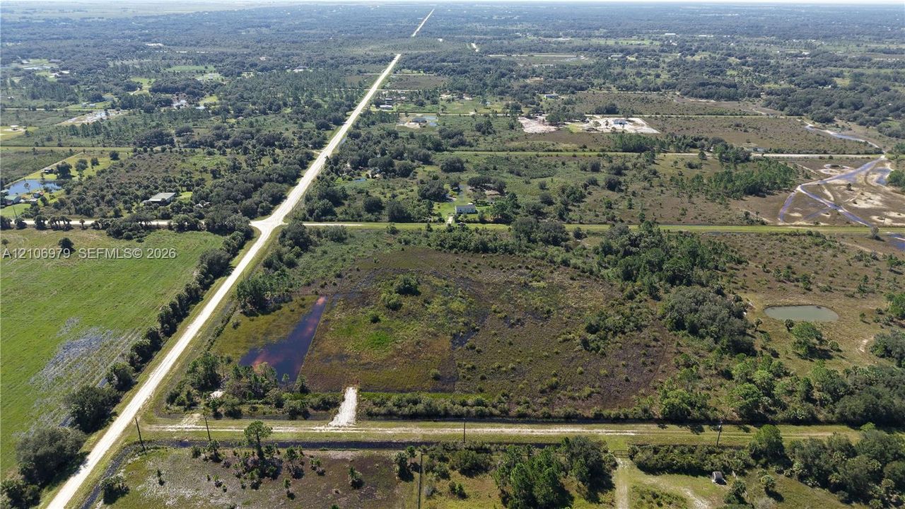 Expansive acreage featuring native vegetation, open natural terrain, and a dedicated gravel entrance path