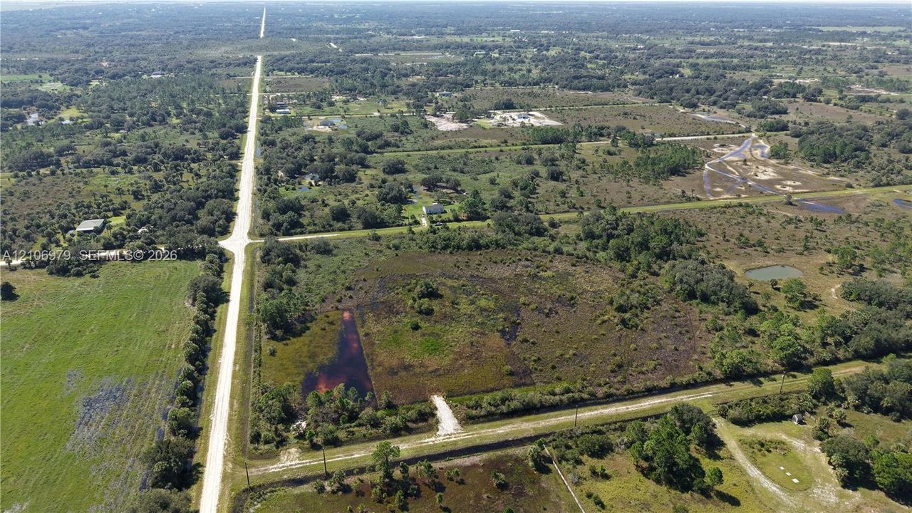 Expansive land parcel featuring road frontage, native vegetation, and natural water features