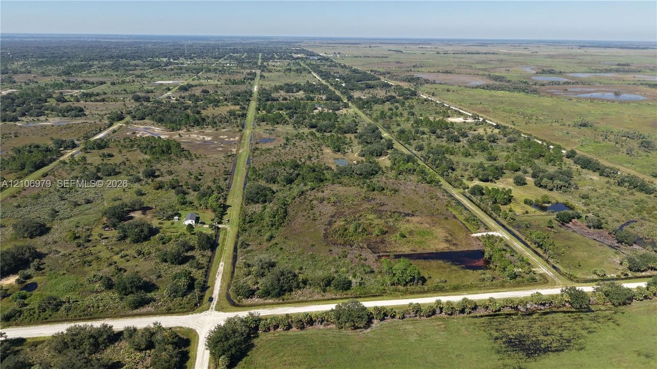 Expansive parcel of acreage featuring mature trees, native vegetation, natural water features, and direct access to graded roadways