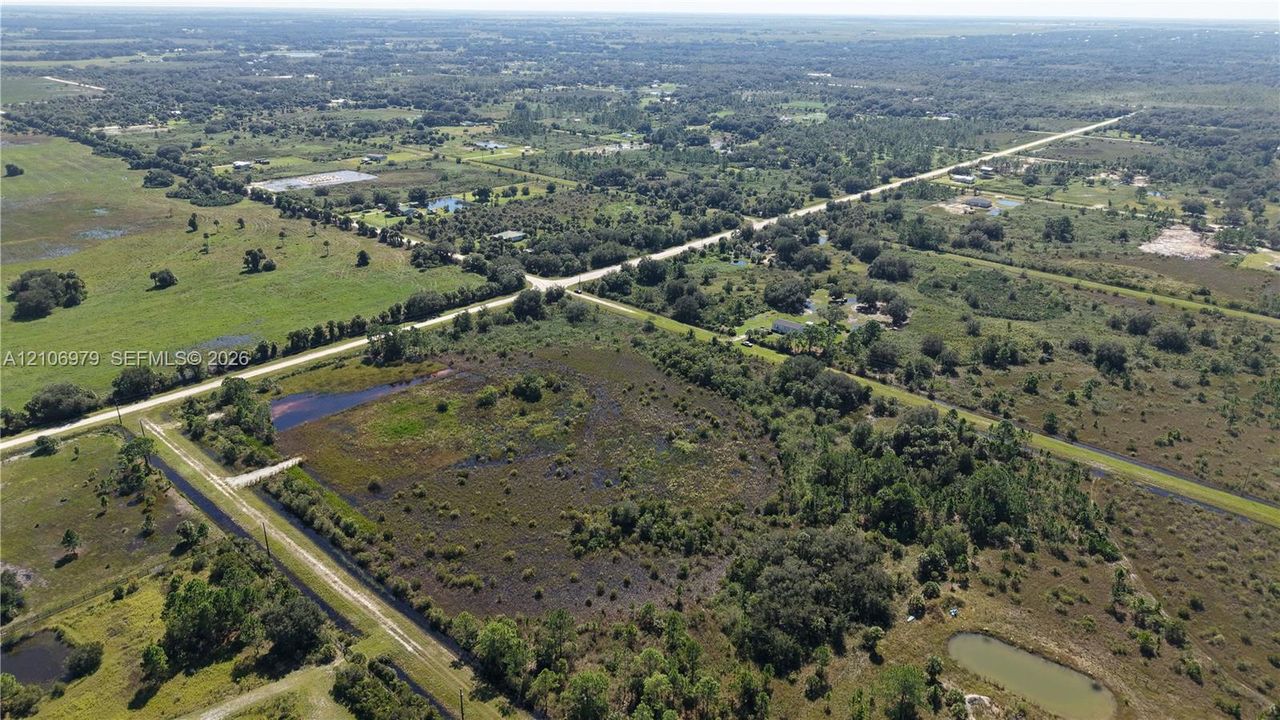 Expansive acreage featuring mature trees, diverse terrain, open pasture areas, and natural ponds