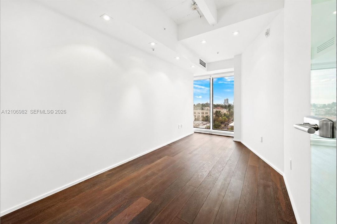 Interior space featuring wood-finish flooring, floor-to-ceiling windows, recessed lighting, and white finished walls