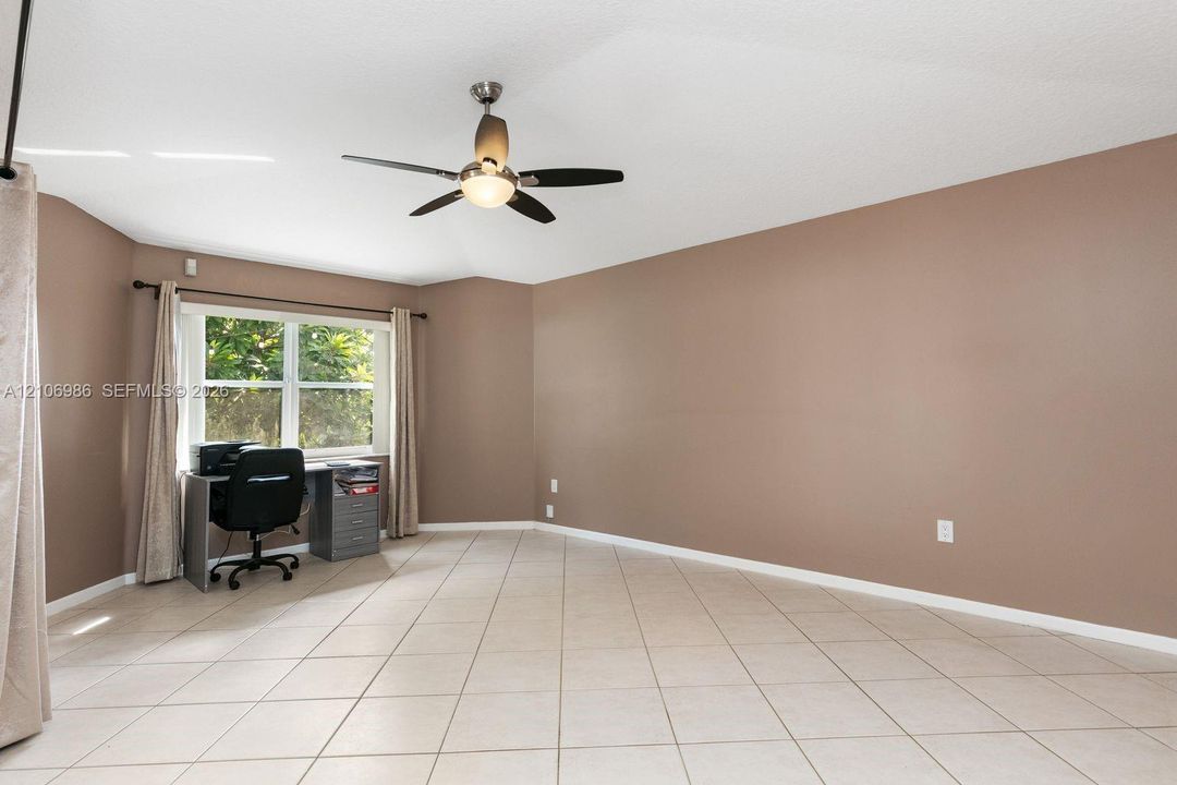 Room featuring large-format diagonal tile flooring, neutral wall paint, and a ceiling-mounted fan with integrated lighting