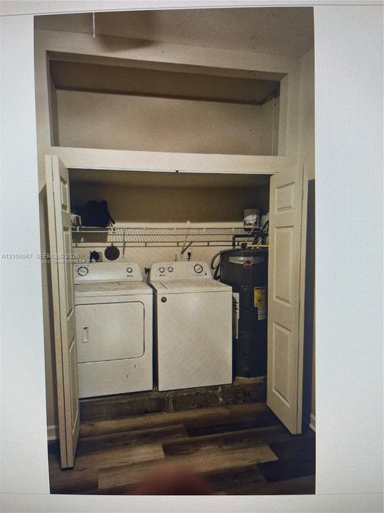 Laundry closet featuring bifod doors, wire shelving, wood-finish flooring, and a dedicated utility space