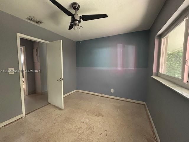 Interior room featuring dual-tone wall paint, a multi-blade ceiling fan with integrated lighting, and a window with a stone-finish sill