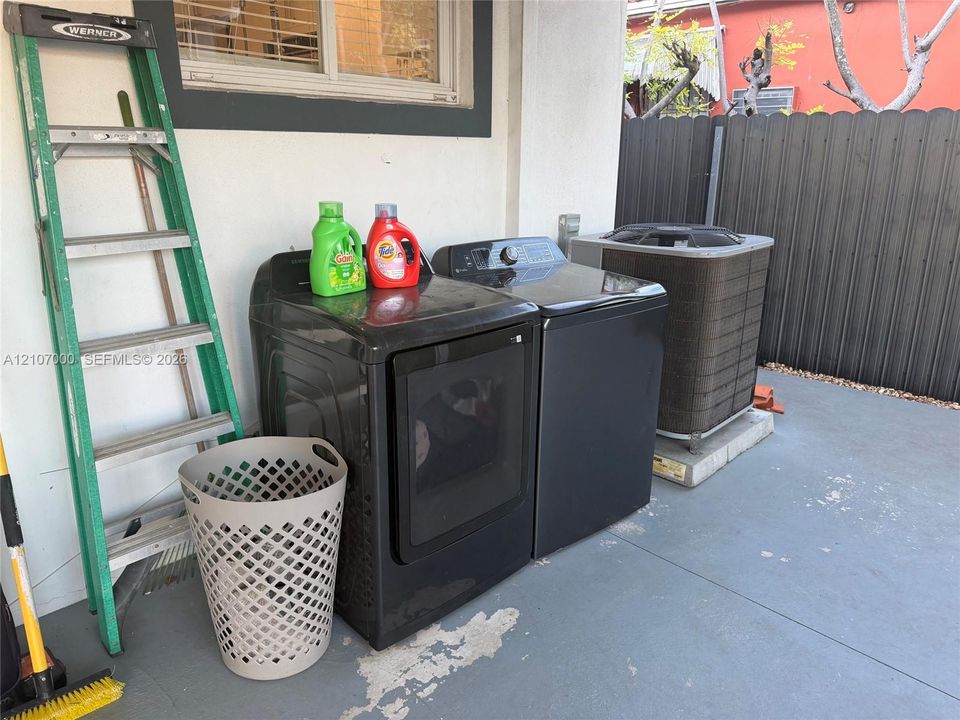 Outdoor laundry area featuring a concrete patio surface and an exterior-mounted heating and cooling unit