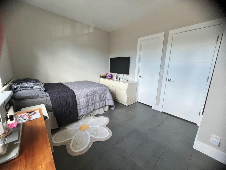 Large-format tile flooring, neutral wall tones, and two solid-core interior doors with satin nickel hardware