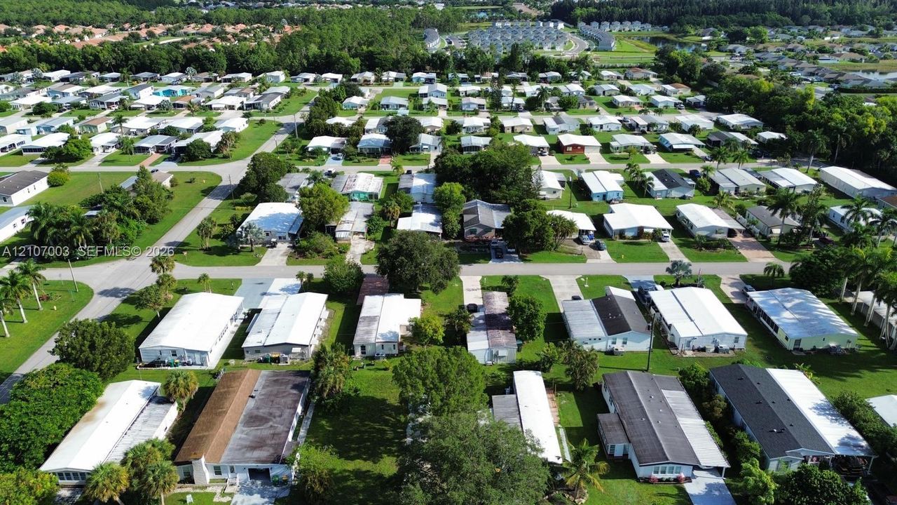 Aerial perspective of a planned community featuring paved grid streets, mature trees, and established landscaping