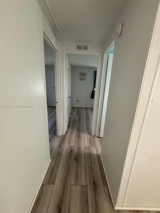 Interior hallway featuring wood-finish flooring and neutral-toned wall paint